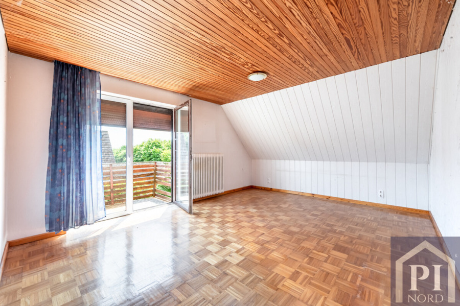 Schlafzimmer mit Zugang zum Balkon und Blick auf die Felder