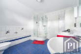 Helles Badezimmer mit Doppelwaschbecken, Dusche und Badewanne