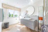 Masterbad mit Hightechtoilette und geschmackvollen Badmöbeln